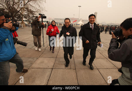 Berühmte chinesische Regisseur Zhang Yimou (C), auch ein chinesischer Delegierter, läuft von der Presse, als er auf dem Platz des Himmlischen Friedens kommt vor der Eröffnung der Chinese People's Political Consultative Conference (Cppcc) in der Großen Halle des Volkes in Peking März 3, 2010. Die chinesische Führung ist, Rechtsvorschriften, fördert das Wirtschaftswachstum und die Verbesserung des Lebensstandards, vor allem unter den Migranten des Landes. UPI/Stephen Rasierer Stockfoto