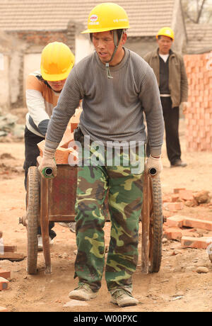 Chinesische Wanderarbeiter haul Backsteine bei einem umstrittenen Baustelle, wo staatlich geschützten Gebäuden durch private Firmen wurden abgerissen, in Peking am 29. April 2010. China letzte Woche versprochen, mit Bauträgern in illegale Praktiken verwickelt. UPI/Stephen Rasierer Stockfoto