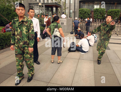 Chinesische Sicherheit um Journalisten der chinesischen Öl Giant's PetroChina Hauptsitz wie eine kleine Gruppe von Arbeitnehmern Protest außerhalb des Gebäudes in Peking am 14. Juli 2010 zu verlassen. China hat eine zunehmende Zahl von Arbeitskräften Proteste in den letzten Wochen gesehen, von Streiks bei einem Honda Factory zu grimmigen Konten der Selbstmord des riesigen foxconn Komplex. UPI/Stephen Rasierer Stockfoto