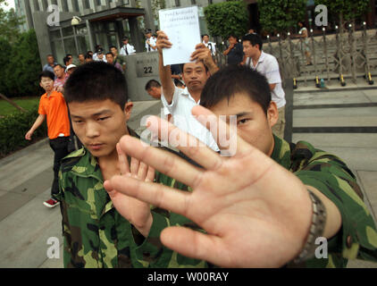 Chinesische Sicherheit um Journalisten der chinesischen Öl Giant's PetroChina Hauptsitz wie eine kleine Gruppe von Arbeitnehmern Protest außerhalb des Gebäudes in Peking am 14. Juli 2010 zu verlassen. China hat eine zunehmende Zahl von Arbeitskräften Proteste in den letzten Wochen gesehen, von Streiks bei einem Honda Factory zu grimmigen Konten der Selbstmord des riesigen foxconn Komplex. UPI/Stephen Rasierer Stockfoto