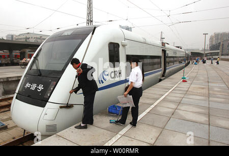 Ein chinesischer Arbeiter reinigt die vor einem Hochgeschwindigkeitszug auf einem Bahnhof in Chengdu, der Hauptstadt der Provinz Sichuan, 29. August 2010. China ist der weltweit längsten Hochgeschwindigkeitsnetz mit ca. 6,920 km (4.300 Meilen) von Hochgeschwindigkeitsstrecken im Juli 2010, darunter 1, 995 km (1.240 Meilen) von Linien mit Höchstgeschwindigkeit von 350 km/h (220 mph). UPI/Stephen Rasierer Stockfoto