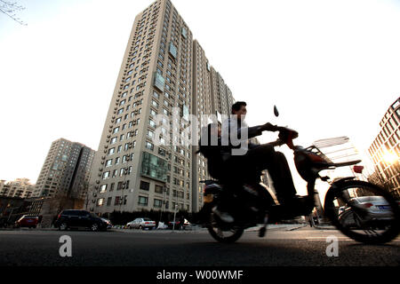 Ein chinesischer Mann fährt mit dem Fahrrad Vergangenheit eine neue Wohnsiedlung in der Innenstadt von Peking, 11. März 2011. Nach dem Überholen die USA als größten Baumarkt in 2010, Chinas Bauwirtschaft mehr als die doppelte Größe von $ 2,5 Bio., 2020. UPI/Stephen Rasierer Stockfoto