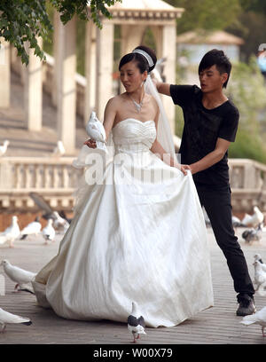 Eine chinesische Braut Posen für Fotos Hochzeit mit Tauben beim Besuch im Beijing World Park am 16. Mai 2011. Der Themenpark versucht, den Besuchern die Möglichkeit, die Welt in Peking zu verlassen, um zu sehen geben. UPI/Stephen Rasierer Stockfoto