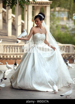 Eine chinesische Braut Posen für Fotos Hochzeit mit Tauben beim Besuch im Beijing World Park am 16. Mai 2011. Der Themenpark versucht, den Besuchern die Möglichkeit, die Welt in Peking zu verlassen, um zu sehen geben. UPI/Stephen Rasierer Stockfoto