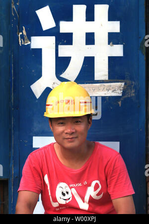 Eine chinesische Bauarbeiter nimmt eine Pause an einem neuen Business Center, entworfen, um den Olympic National Stadium ähneln, in Peking am 31. Juli 2011. Über die Hauptstadt Chinas, in der städtischen Regierung versucht, die Größe des Central Business District von Peking, die bereits die höchste Leerstandsquote, die jemals in der Stadt aufgezeichnet zu verdoppeln, um 40-50 Prozent schweben, nach China. "China ist der einzige Ort in der Welt, trotz mehr leeren Gebäuden, als der Rest der Welt hat doch die Bewertungen auf ihre Bilanz', Präsident der globalen Distre Stockfoto