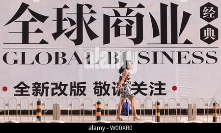 Eine chinesische Frau geht vorbei am großen bürgersteig Werbung für Büroräume in einem neuen internationalen Business Center in der Innenstadt von Peking am 2. August 2011. Die Schuldenprobleme der Vereinigten Staaten noch immer eine Bedrohung für die globale Wirtschaft trotz einer Last-minute-Abkommen, das durch das Weiße Haus und die politische Parteiführer, Chinas offizielle Zeitung Struck sagte am Dienstag, dennoch hinzufügen gab es keine kurzfristige Flucht aus der Dominanz des Dollars. UPI/Stephen Rasierer Stockfoto