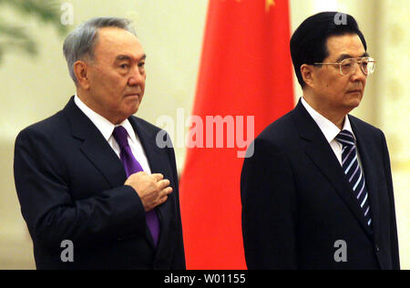 Der chinesische Präsident Hu Jintao (R) und Kasachstans Präsident Nursultan Nasarbajew hören zu ihren jeweiligen Nationalhymnen während der Begrüßungszeremonie in der Großen Halle des Volkes in Peking am 6. Juni 2012. Präsidenten von Tadschikistan, Kirgisistan, Russland, Kasachstan, Turkmenistan, Usbekistan, Afghanistan, Pakistan und Iran sind in Chinas Hauptstadt für die 12. Tagung des Rates der Regierungschefs der Shanghaier Organisation für Zusammenarbeit Gipfel. UPI/Stephen Rasierer Stockfoto