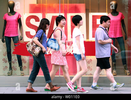 Chinesische Käufer vorbei an einem internationalen Kleidung Boutique mit einem Verkauf auf sein Sommer Kollektion in einer neuen Mall in Peking am 5. August 2012. Schwachen Konsumausgaben in China zeichnet sich als ein wesentliches Hindernis für ein nachhaltiges Wachstum des Landes. UPI/Stephen Rasierer Stockfoto