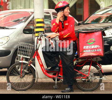 Eine chinesische Pizza Hut Lieferung Mann bittet um Richtungen, während in Peking am 23. August 2012. Der Pizza Hut erste chinesische Restaurant eröffnet in Peking in den frühen 90er Jahren und hat heute über 600 Filialen bundesweit. UPI/Stephen Rasierer Stockfoto