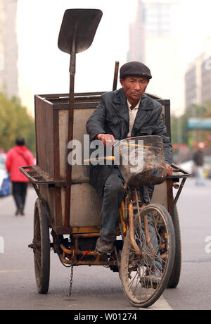 Mit niedrigem Einkommen der chinesischen Kehrmaschinen und Müllsammler Fahrrad fahren, wie Sie die Straßen von Downtown Beijing patrouille am 9. November 2012. Der chinesische Präsident Hu Jintao, in der Bereitstellung der Arbeitsgruppe Bericht zum 18. Kongress der Kommunistischen Partei, warnte die zukünftigen Führer des Landes, dass eine immer grösser werdende Einkommensschere im ganzen Land ist die Schaffung sozialer Instabilität. China wird in Kürze neue Führer, viele, die Millionäre sind, während Millionen von Chinesen noch auf $ 1 pro Tag leben. UPI/Stephen Rasierer Stockfoto