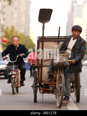 Mit niedrigem Einkommen der chinesischen Kehrmaschinen und Müllsammler Fahrrad fahren, wie Sie die Straßen von Downtown Beijing patrouille am 9. November 2012. Der chinesische Präsident Hu Jintao, in der Bereitstellung der Arbeitsgruppe Bericht zum 18. Kongress der Kommunistischen Partei, warnte die zukünftigen Führer des Landes, dass eine immer grösser werdende Einkommensschere im ganzen Land ist die Schaffung sozialer Instabilität. China wird in Kürze neue Führer, viele, die Millionäre sind, während Millionen von Chinesen noch auf $ 1 pro Tag leben. UPI/Stephen Rasierer Stockfoto