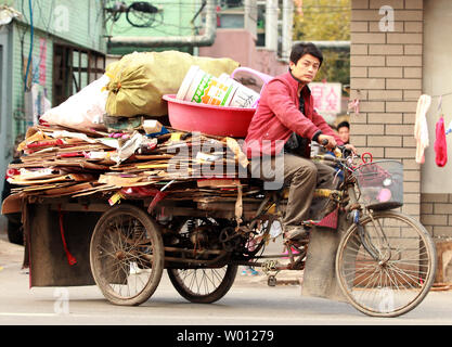 Mit niedrigem Einkommen der chinesischen Kehrmaschinen und Müllsammler Fahrrad fahren, wie Sie die Straßen von Downtown Beijing patrouille am 9. November 2012. Der chinesische Präsident Hu Jintao, in der Bereitstellung der Arbeitsgruppe Bericht zum 18. Kongress der Kommunistischen Partei, warnte die zukünftigen Führer des Landes, dass eine immer grösser werdende Einkommensschere im ganzen Land ist die Schaffung sozialer Instabilität. China wird in Kürze neue Führer, viele, die Millionäre sind, während Millionen von Chinesen noch auf $ 1 pro Tag leben. UPI/Stephen Rasierer Stockfoto