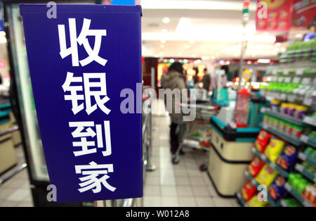 Chinesische Käufer befassen sich mit ungewöhnlich geschlossen Check-out Gassen in einem normalerweise besetzt Supermarkt in Peking am 24. Dezember 2012. Trotz der wirtschaftlichen Indikatoren zeigen eine langsame Erholung in Chinas Wachstum, inländische Erhebungen zeigen eine Verschärfung der Ausgaben des Landes entstehenden Mittelschicht, vor allem auf die täglichen Lebensmittel kauft. UPI/Stephen Rasierer Stockfoto