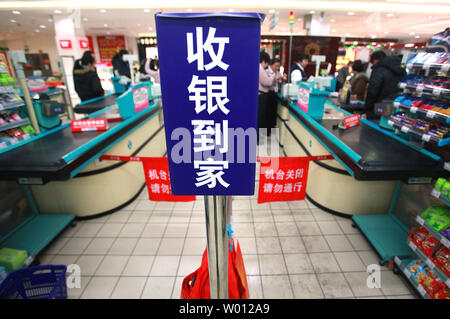 Chinesische Käufer befassen sich mit ungewöhnlich geschlossen Check-out Gassen in einem normalerweise besetzt Supermarkt in Peking am 24. Dezember 2012. Trotz der wirtschaftlichen Indikatoren zeigen eine langsame Erholung in Chinas Wachstum, inländische Erhebungen zeigen eine Verschärfung der Ausgaben des Landes entstehenden Mittelschicht, vor allem auf die täglichen Lebensmittel kauft. UPI/Stephen Rasierer Stockfoto