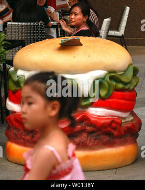 Eine chinesische Frau isst Mittag außerhalb eines neuen Burger King fast food Restaurant in der Innenstadt von Peking am 28. Juni 2013. Chinesische Gesundheit Beamte sind Schuld die Aufkommen einer westlichen fast food Revolution im ganzen Land boomt als Hauptursache der zunehmenden Übergewichtigkeit in China. Adipositas in China, besonders unter Kindern, hat ein wachsendes Gesundheitsproblem geworden, die nicht nur ernsthaft die Gesundheit der zukünftigen Generationen auswirken, sondern auch eine schwere wirtschaftliche Belastung für das Land. UPI/Stephen Rasierer Stockfoto