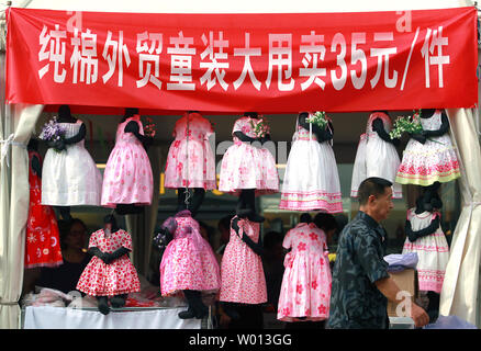 Ein chinesischer Mann vorbei an einem freien Markt Exporteure, mit einem Shop für Kleider der jungen Mädchen für ca. US $ 6 ein Stück, im Zentrum von Peking am 12. August 2013. Chinas Handel erholt, die im Juli in einem möglichen Zeichen, dass weltweit die Nummer zwei Wirtschaft Stabilisierung nach einer alarmierenden Rückgang im letzten Jahr ist. UPI/Stephen Rasierer Stockfoto