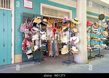 An Ständen außerhalb eines Bekleidungsladens hängen Hutregale Stockfoto