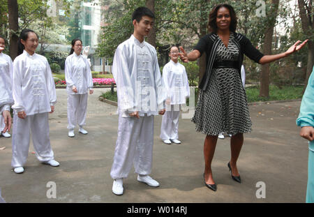 First Lady der USA Michelle Obama lacht mit der Presse als Sie erfährt ein paar Anfänger bewegt sich mit einer Tai Chi Klasse an der Zahl sieben High School in Chengdu, der Hauptstadt der Provinz Shaanxi, am 25. März 2014. UPI/Stephen Rasierer Stockfoto