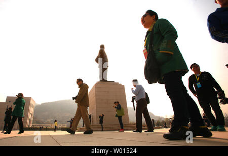 Chinesische vorbei durch eine große Statue von Chinas ehemaligen Steuermann Mao Zedong bei der Ankunft im Revolutionären Memorial Hall, präsentiert die Ereignisse, die zu der Entstehung der Volksrepublik China führte, in Yan'an, Provinz Shaanxi, am 6. April 2014. Yan'an war in der Nähe der Endpunkt der Langen Marsch, und wurde zum Zentrum der Chinesischen Kommunistischen Revolution führte meine Mao von 1936 bis 1948. Die chinesischen Kommunisten feiern die Stadt als Geburtsstätte des modernen China und der Kult von Mao. UPI/Stephen Rasierer Stockfoto