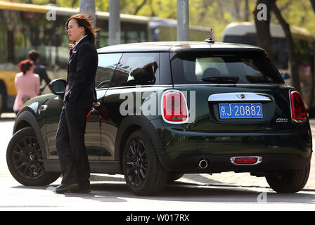 Eine chinesische Frau steht neben ihr Mini Cooper in der Nähe einer stark befahrenen Kreuzung in Peking am 20. April 2015. Chinas entstehenden Mittelschicht, erklaerte nun auf rund 500 Millionen Euro (mehr als die gesamte US-Bevölkerung von rund 320 Millionen Euro), hat China größten Automobilhersteller der Welt zu werden und den Markt. Foto von Stephen Rasierer/UPI Stockfoto