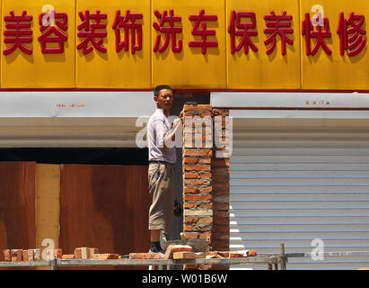 Ein chinesischer Arbeiter baut eine Mauer zwischen zwei Garagen im Zentrum von Peking am 27. Juni 2016. Turbulenzen unleashed von dem Britischen Abstimmung auf die Europäische Union (EU) verlassen erhöhte Ängste in Asien mit China, Japan und Südkorea alle über das finanzielle Risiko für ihre Volkswirtschaften alarmiert. Chinas Finanzminister sagte Fallout aus der vergangenen Woche Referendum" wird ein Schatten über der globalen Wirtschaft" werfen. Foto von Stephen Rasierer/UPI Stockfoto