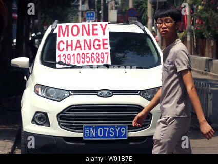 Ein chinesischer Student an einem strassenrand Geld Wechsler, in der Regel mit US-Dollar, die sich, neben den touristischen Bereich in Peking am 30. Juni 2016. Viele ausländische Touristen, in der Hoffnung, eine günstigere USD-Wechselkurs mit dem chinesischen Yuan zu erhalten, häufig besuchen lokale Geldwechsler. China verpflichtet während der bilateralen Gespräche weiter zu 'markt-orientierten Wechselkurs Reform, die für die wechselseitige Flexibilität" der Yuan Währung erlaubt. Foto von Stephen Rasierer/UPI Stockfoto