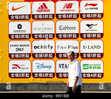 Ein chinesischer Mann hinter einem Rabatt, internationale Kleidung Mall in Peking am 2. Oktober 2016. Die Welthandelsorganisation (WTO) in der letzten Woche spiegelt sich ein konjunktureller Abschwung in China und sinkende Niveau der Einfuhren in die Vereinigten Staaten aus der weltweit zweitgrößte Wirtschaft durch die Kaufkraft. Foto von Stephen Rasierer/UPI Stockfoto