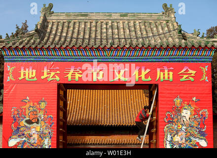 Ein chinesischer Arbeiter legt den letzten Schliff für das Aufhängen von großen Tempel Gottes Wandmalereien auf der Vorderseite Tor von einem Tempel in Peking am 29. Januar 2018. Chinas Hauptstadt rüstet sich für die anstehende Chinesisches Neujahr und Spring Festival, das wird das Jahr des Hundes sein. Foto von Stephen Rasierer/UPI Stockfoto