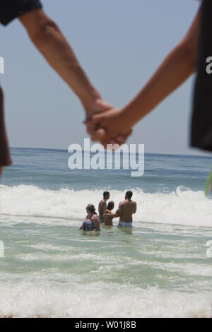 Touristische Schwimmen in der Brandung, als mehrere hundert Menschen Pensacola Beach für die Hände über dem Sand Protest in Pensacola Beach, Florida, 26. Juni 2010. Hände über den Sand ist offshore Öl bohren zu protestieren. UPI/Mark Wallheiser Stockfoto