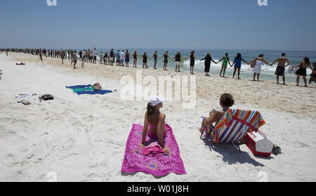 Touristische zusehen, wie mehrere hundert Menschen Pensacola Beach für die Hände über dem Sand Protest in Pensacola Beach, Florida, 26. Juni 2010. Hände über den Sand ist offshore Öl bohren zu protestieren. UPI/Mark Wallheiser Stockfoto