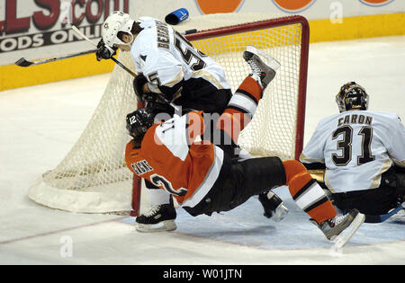 Der pinguine Drake Berehowsky (55) Nimmt Flyer Simon Gagne (12) von den Füßen während einer Scoring versuchen auf Torwart Sebastien Caron (31) wie Philadelphia hosts Pittsburgh an der Wachovia Center in Philadelphia, am 3. Dezember 2003. UPI Foto/Jon AdamsI) Stockfoto