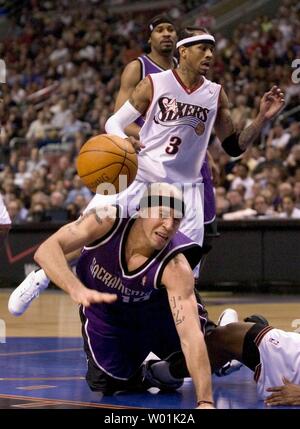 Die Könige' Mike Bibby (10) fällt in immer umgarnt mit den 76ers' Eric Snow (20) und Allen Iverson (3) als Philadelphia Sacramento in einem Abend Spiel im Wachovia Center in Philadelphia, Hosts, am 4. März 2004. (UPI FOTO/Jon Adams) Stockfoto
