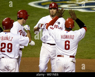 Philadelphia Phillies Jayson Werth ist zu Hause Platte von Ryan Howard (6) und Chase Utley, der auf seiner Home Run im ersten Inning von Spiel 5 der National League Championship Series in Philadelphia zählte am 21. Oktober 2009 begrüßt. Am Recht ist Raul Ibanez (29), Fledermaus wartet. UPI/John Anderson Stockfoto