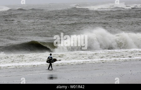 Ein einsamer Surfer geht auf die hohen Wellen am Strand in Atlantic City, New Jersey nach Hurrikan Irene der Bereich am 28. August 2011. Die Kategorie 1 Sturm hat die Jersey Shore nicht Schaden so viel wie erwartet, aber massive Überflutungen erwartet wird. UPI/John Anderson Stockfoto