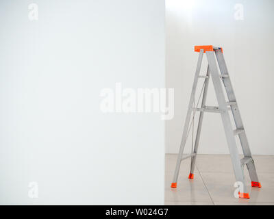 Aluminium Faltleiter. Stehleiter auf weißer Wand Hintergrund mit kopieren. Stockfoto