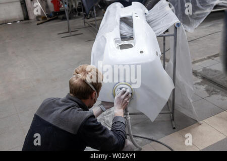 Vorbereitung für die Lackierung eines Autos mit Sander und Putty durch einen Servicetechniker, Nivellierung, bevor Sie eine Grundierung nach Beschädigung eines Bauteils der Stockfoto
