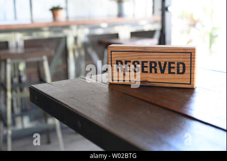 Restaurant einen reservierten Tisch Zeichen reservierten Tisch. Ein Tag der Reservierung auf dem Holz Tisch Stockfoto