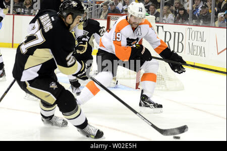 Pittsburgh Penguins rechten Flügel Craig Adams (27.) spielt den Puck vom Philadelphia Flyers linken Flügel Scott Hartnell (19) an der Consol Energy Center in Pittsburgh am 13. November 2013. UPI/Archie Tischler Stockfoto