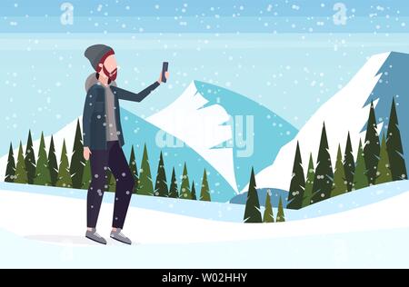 Menschen, die auf dem Smartphone selfie Foto Kamera casual männliche Zeichentrickfigur, die verschneiten Berge Landschaft Hintergrund Flachbild in voller Länge Stock Vektor