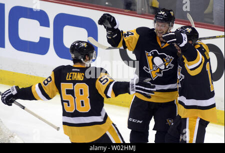 Pittsburgh Penguins defenseman Kris Letang (58) Skates in die Feier der Pittsburgh Penguins rechten Flügel Tom Kuhnhackl (34) Ziel in der dritten Periode der 5-2 über den New York Rangers in Spiel eins der Eastern Conference Endspiele an den Consol Energy Center in Pittsburgh am 13. April 2016. Foto von Archie Tischler/UPI Stockfoto