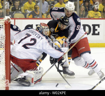 Pittsburgh Penguins center Nick Bonino (13) erreicht Vergangenheit Columbus Blue Jackets goalie Sergei Bobrovsky (72) und Columbus Blue Jackets defenseman Gabriel Carlsson (53) in der zweiten Periode von Spiel eins der NHL Eastern Conference Playoff Serie auf der PPG Malt Arena in Pittsburgh am 12. April 2017. Foto von Archie Tischler/UPI Stockfoto