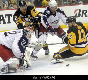 Pittsburgh Penguins center Nick Bonino (13) fällt zu Eis wie Columbus Blue Jackets goalie Sergei Bobrovsky (72), Columbus Blue Jackets defenseman Jack Johnson (7) und die Pittsburgh Penguins rechten Flügel Patric Hornqvist (72) folgt der Puck während des zweiten Zeitraums von Spiel eins der NHL Eastern Conference Playoff Serie auf der PPG Malt Arena in Pittsburgh am 12. April 2017. Foto von Archie Tischler/UPI Stockfoto