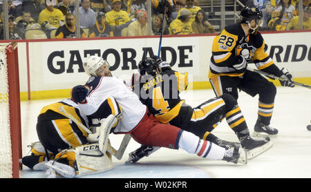 Pittsburgh Penguins defenseman Justin Schultz (4) und Columbus Blue Jackets linke Flügel Nick Foligno (71) fallen in Penguins goalie Treber - Andre Fleury (29) wie Pinguine defenseman Ian Cole (28) löscht den Puck vom Ziel während der dritten Periode der Pinguine 3-1 Sieg in Spiel eins der NHL Eastern Conference Playoff Serie auf der PPG Malt Arena in Pittsburgh am 12. April 2017. Foto von Archie Tischler/UPI Stockfoto