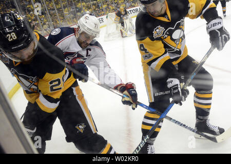 Pittsburgh Penguins defenseman Ian Cole (28) und Pinguine defenseman Justin Schultz (4) Team die Columbus Blue Jackets zu halten linke Flügel Nick Foligno (71) weg von den Puck in der dritten Periode der Pittsburgh Penguins 3-1 in Spiel eins der NHL Eastern Conference Playoff Serie auf der PPG Malt Arena in Pittsburgh am 12. April 2017 zu gewinnen. Foto von Archie Tischler/UPI Stockfoto