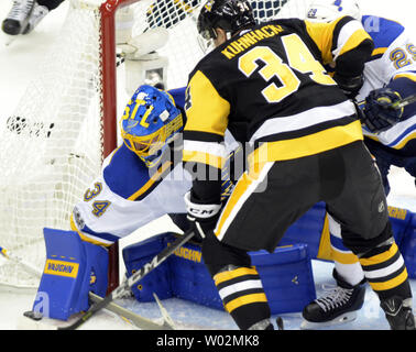 St. Louis Blues goalie Jake Allen (34) löscht den Puck von Pittsburgh Penguins rechten Flügel Tom Kuhnhackl (34) während des zweiten Zeitraums des Hauptöffner der Pittsburgh Penguins am PPG Malt Arena in Pittsburgh am 4. Oktober 2017. Foto von Archie Tischler/UPI Stockfoto