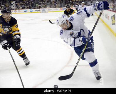 Tampa Bay Lightning center Tyler Johnson (9) spielt den Puck pass Pittsburgh Penguins rechten Flügel Tom Kuhnhackl (34) In der dritten Periode der Pinguine 5-2 gewinnen bei PPG Malt Arena in Pittsburgh am 25. November 2017. Foto von Archie Tischler/UPI Stockfoto