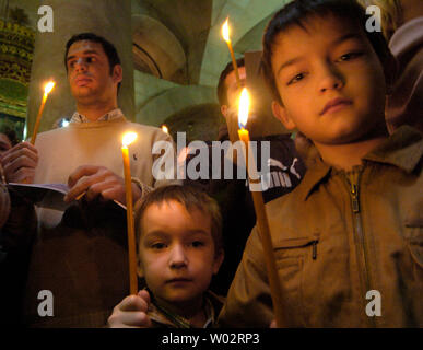 Christen halten Sie Kerzen während des Römisch-katholischen Ostern Sonntag die Messe in der Kirche des Heiligen Grabes in der Altstadt von Jerusalem, 27. März 2005. Tradition glaubt, der Jesus Christus als den gekreuzigten, begrabenen und in der Kirche des Heiligen Grabes auferstanden. (UPI Foto/Debbie Hill) Stockfoto