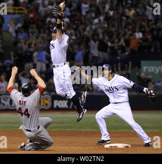 Tampa Bay Rays zweite Basisspieler Akinori Iwamura (C) und shortstop Jason Bartlett feiern wie Boston Red Sox outfielder Jason Bay in zweiten Folien wie die Strahlen die Niederlage der Red Sox 3-1 der American League Meisterschaft an der Tropicana Field in St. Petersburg, Florida am 19. Oktober 2008 zu gewinnen. Die Strahlen werden die Philadelphia Phillies in Ihren ersten World Series aussehen. (UPI Foto/Kevin Dietsch) Stockfoto