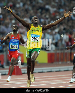 Jamaikas Usain Bolt jubilates, als er die Ziellinie überquert und sieht, dass er die Goldmedaille gewonnen hat und den Weltrekord im 200 Meter Rennen gebrochen an der National Stadium bei den Olympischen Sommerspielen in Peking am 20. August 2008. Schraube einen neuen Weltrekord von 19,30 Sekunden, brechen die USA Michael Johnson den Rekord von 19.32 im Jahr 1996 eingestellt. Auf der linken Seite ist silbermedaillengewinner Churandy Martina (1003) der Niederländischen Antillen. (UPI Foto/Pat Benic) Stockfoto