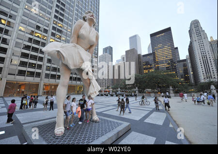 Menschen posieren für Fotos mit 'Forever Marilyn", einer Skulptur von Seward Johnson, am 15. Juli 2011 bei Pioneer Plaza in Chicago. Inspiriert von Marilyn MonroeÕs kultigen Pose aus dem Jahr 1955 Film ist sogar Jahr Itch", Edelstahl und Aluminium Skulptur steht 26 Meter hoch und wiegt 34.000 Pfund und wird auf dem Display durch die Frühjahr 2012. UPI/Brian Kersey Stockfoto